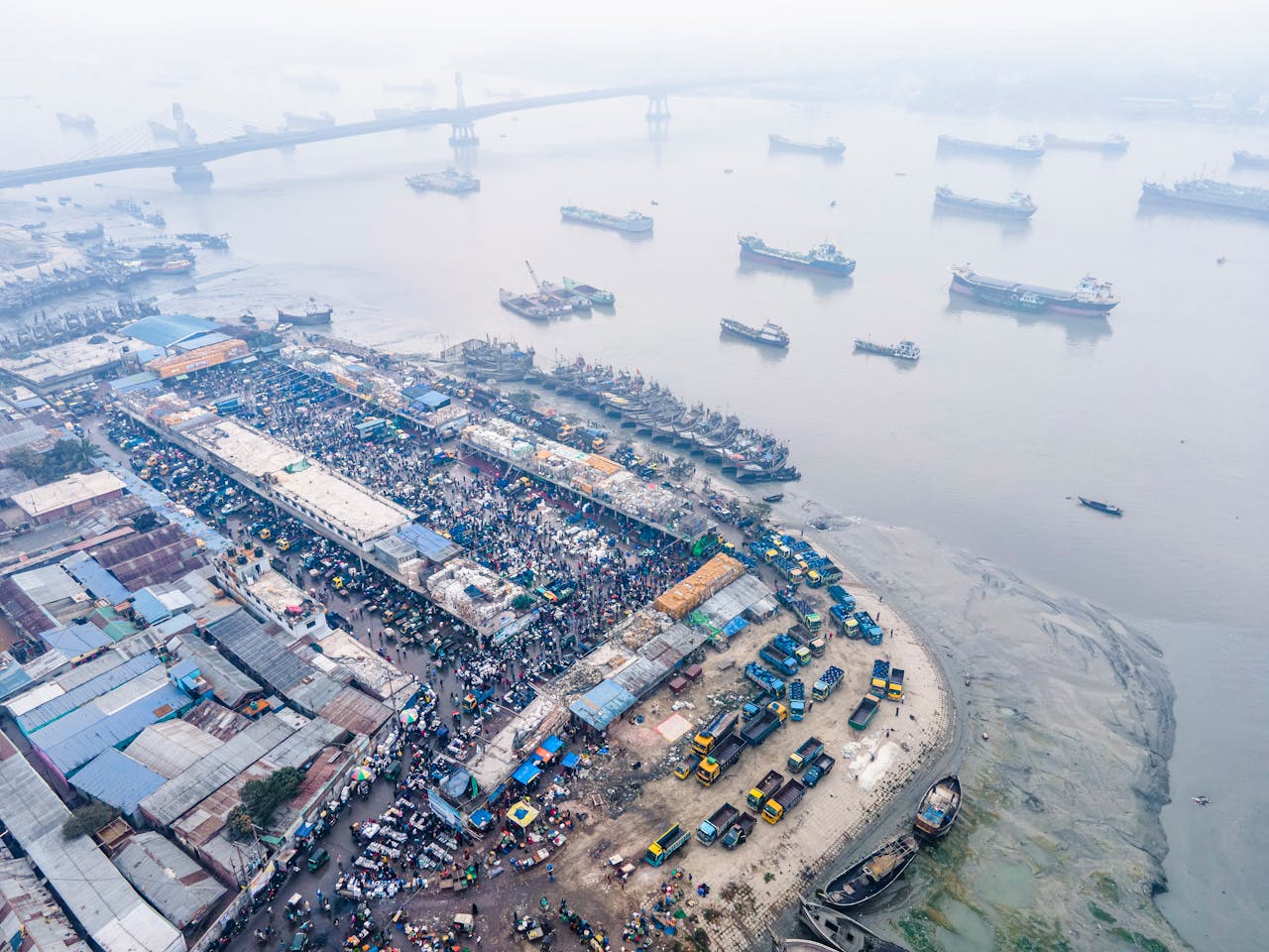 Aerial photo showcasing bustling activity at Chittagongs industrial port with ships and trucks.